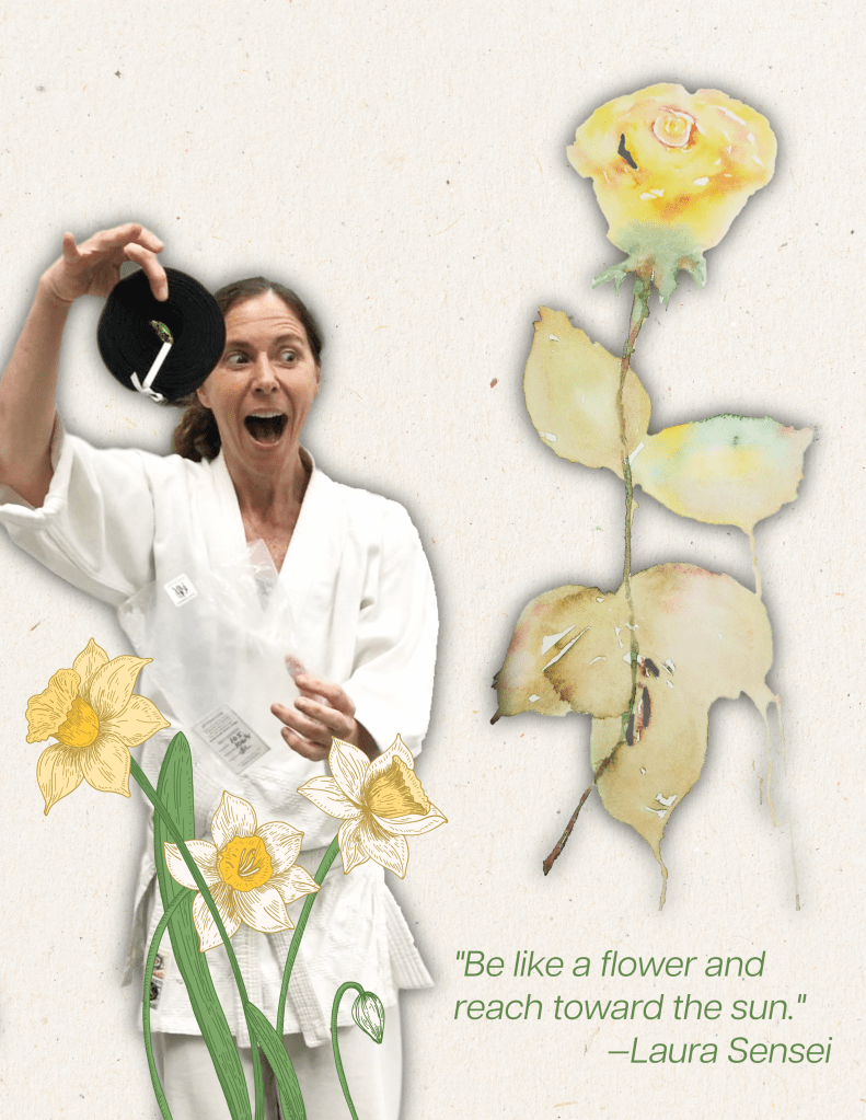 A photo illustration of Laura Whites Sensei surrounded by white and yellow flowers holding up her brand new black belt.